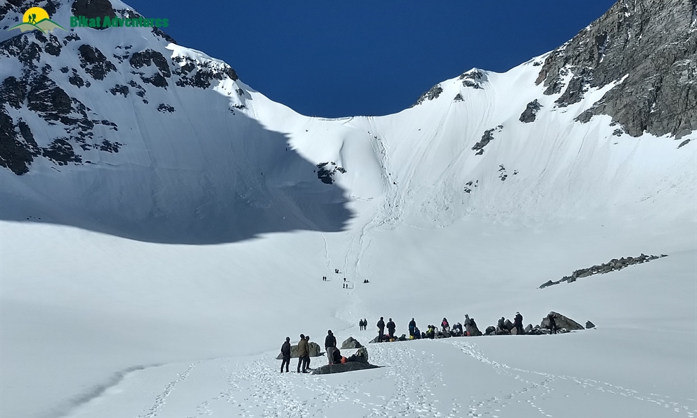 Trekkers rappelling down Buran Ghati snow wall