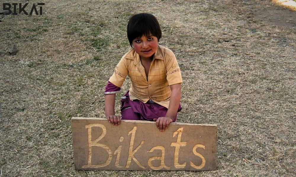 Mountain baby holding a Bikat Play card