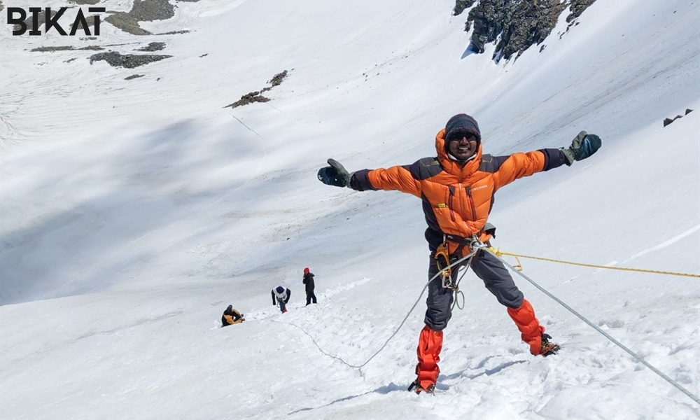 a trekker hanging on the rope on snowy slop in snow covered mountain 