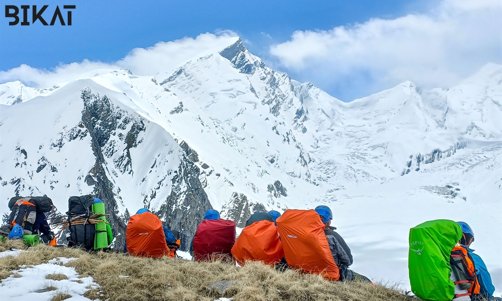 6-7 Trekkers Resting with a snow covered mountain in front of them while on their way to summit.